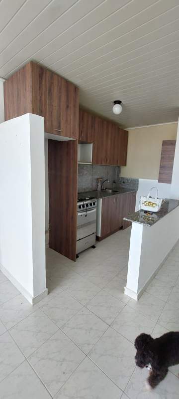 Compact modern kitchen with granite countertop, wooden cabinets, and gas stove in PH Campo Lindbergh Panama