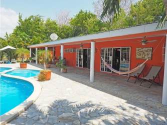 Covered outdoor bar and dining patio surrounded by greenery in Nueva Gorgona Panama