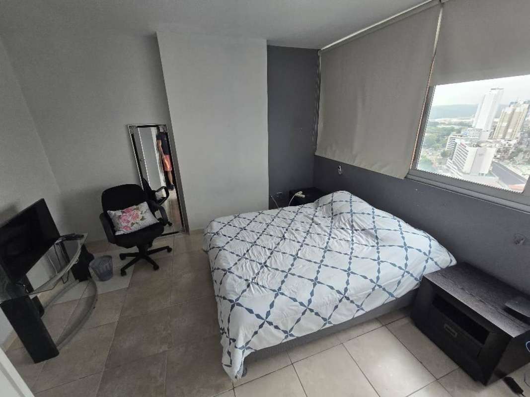 Modern bathroom with glass shower enclosure vanity and mirror in Marbella Tower apartment Panama