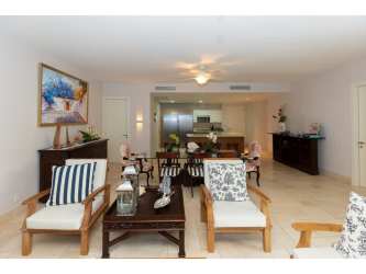 Bright open concept dining and living room with garden views in Buenaventura Resort apartment Panama