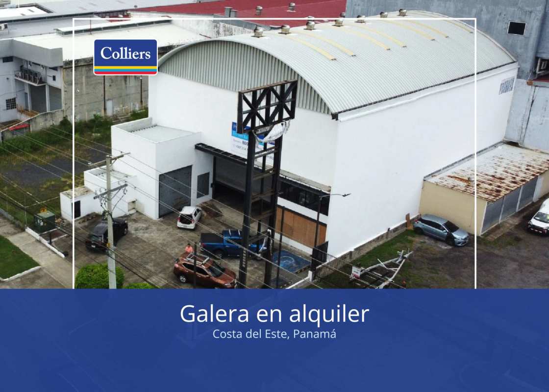 Modern industrial warehouse facade with arching metal roof and gated entrance in Costa del Este