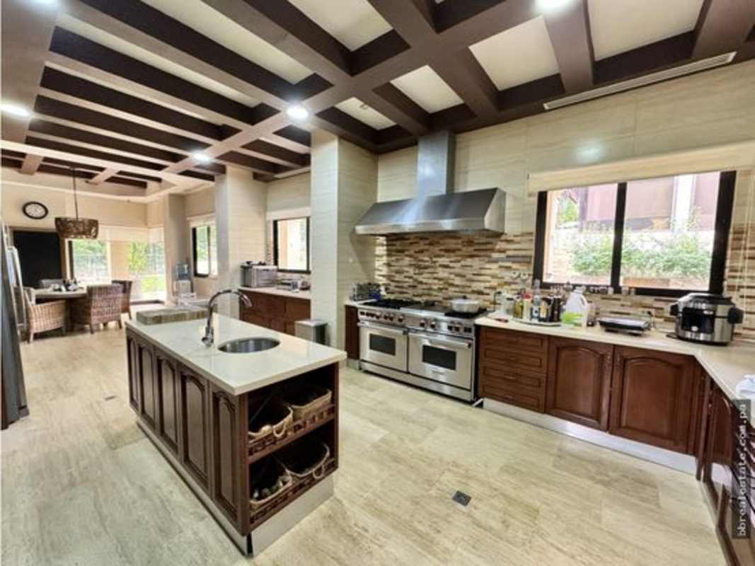 Elegant living room with high ceilings, wood accents, large windows in luxury estate Clayton Panama