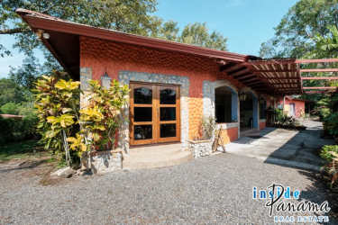Terracotta walls, stone accents, wood doors, pergola patio in lush green setting Boquete Chiriquí