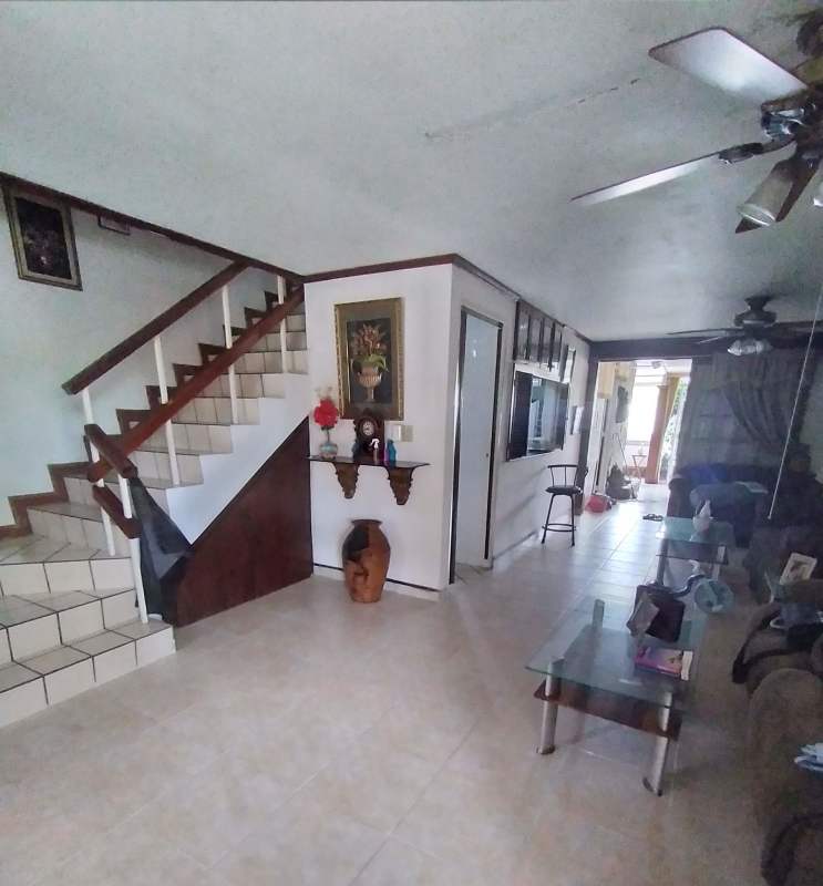 Entry hall with staircase, tiled floor and wood decor in residential house Panama City