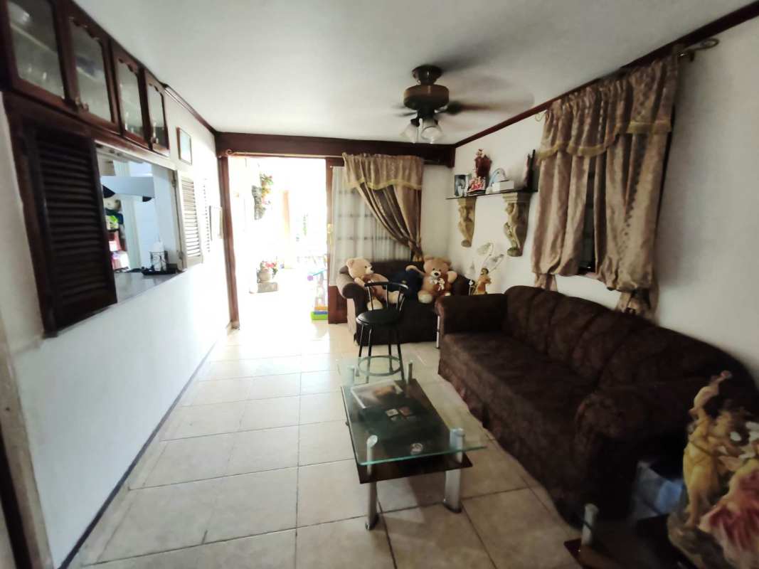 Kitchen with stone accent, wooden cabinets and breakfast bar in Altos de Panama house