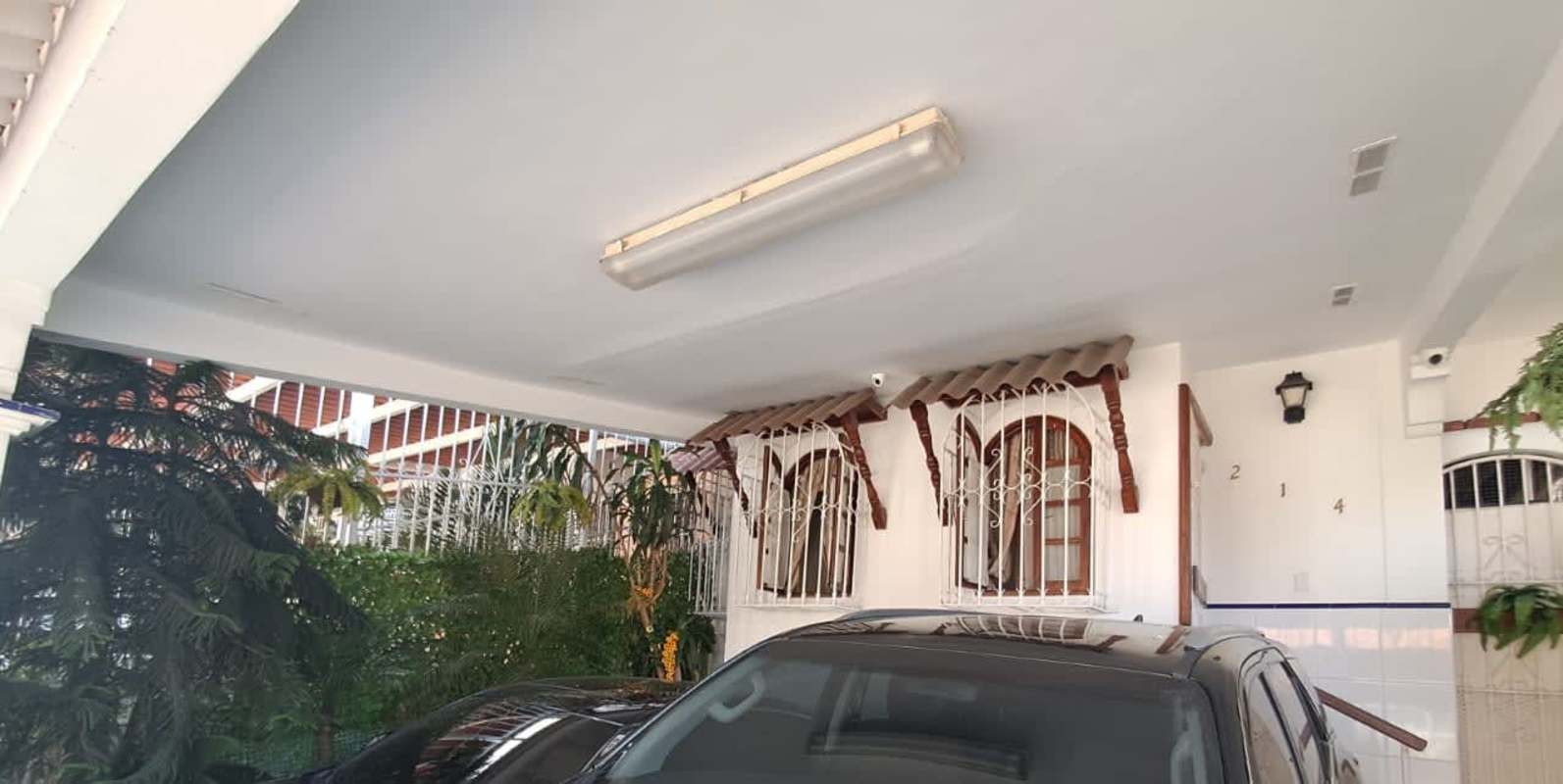 Entrance with tiled stairs, railing, gate and carport in Altos de Panama house