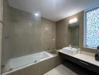 Bright living and dining space with sliding glass doors to terrace overlooking resort pool at Terrazas Villas Playa Blanca Panama