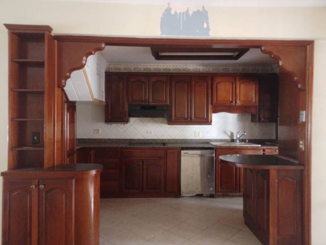 Large kitchen with dark wood cabinets, granite countertops, open arch window, in Villa Soberanía Edison Park Panama