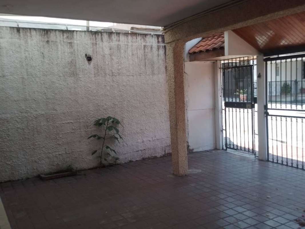 Spacious covered garage with tiled floors and metal gate at Villa Soberanía house Panama
