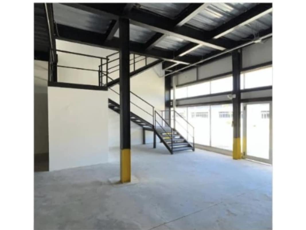Interior with metal stairs mezzanine high ceilings large windows loading bays Ciudad Radial Juan Diaz Panama