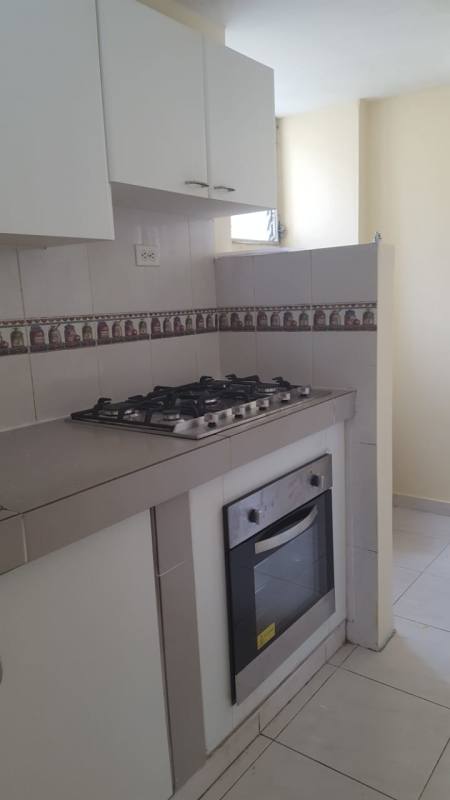 Kitchen with white cabinets, tile counters and built-in appliances in apartment in Condado del Rey Panama