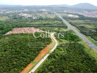 Large green industrial commercial land near suburban development and Pan-American Highway in Panama