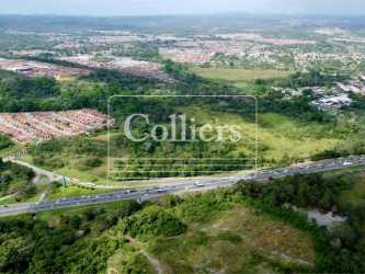 Panorama view of commercial land bordered by highway and suburban development Panama Oeste
