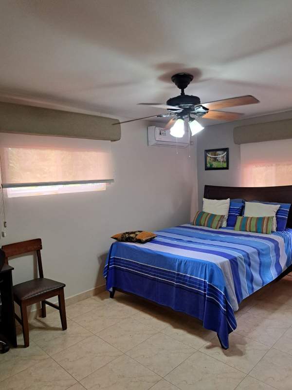 Staircase with ornamental iron railing leading to bright living area Cardenas Village Panama