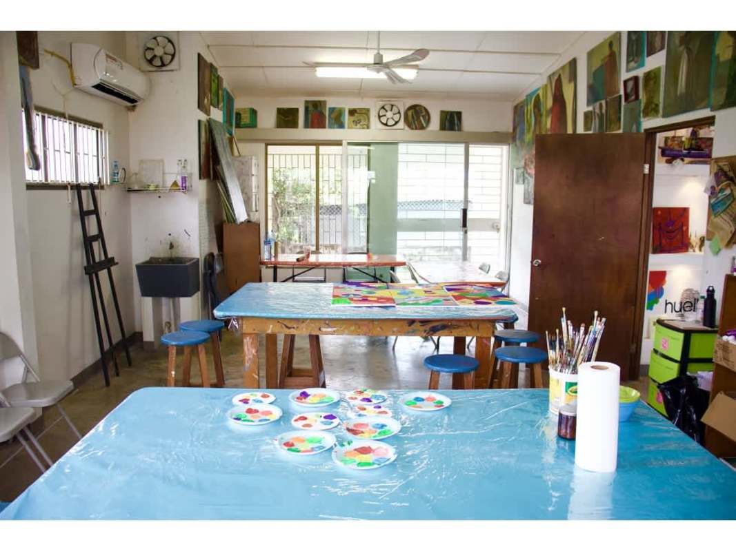 Creative workspace with large tables, stools, and painting supplies ideal for artists in Panama City