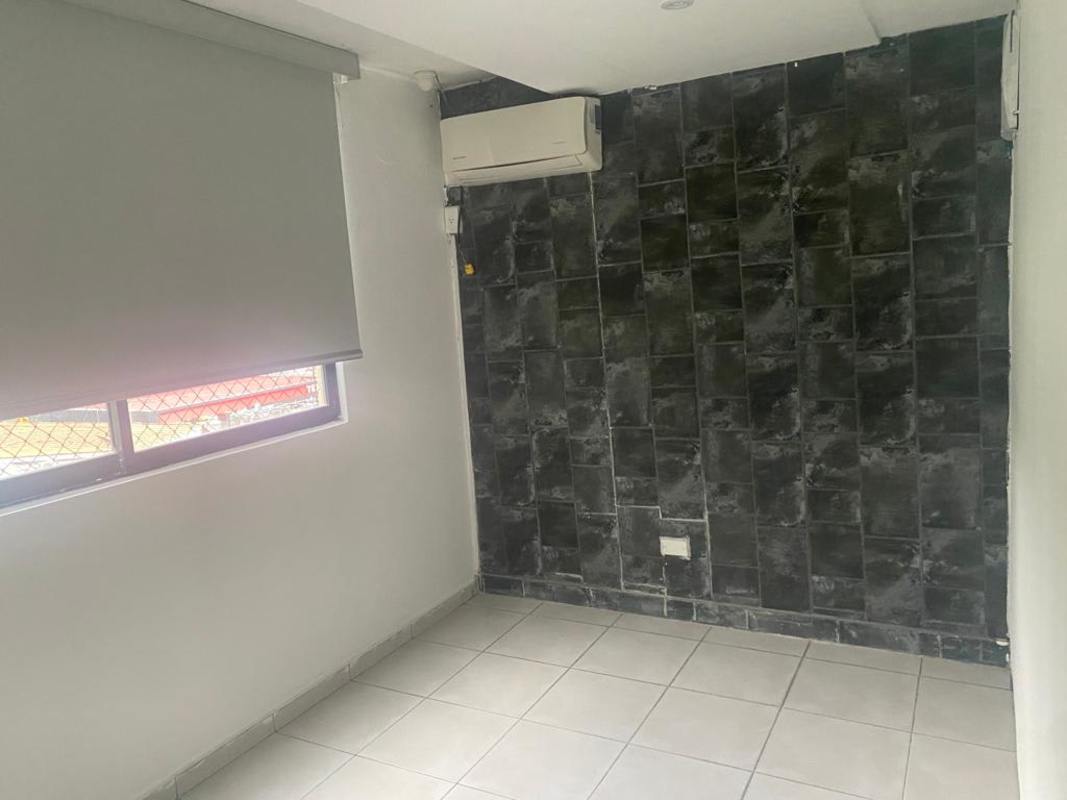 Bedroom featuring dark tile accent wall and split AC setup at PH Mirador San Francisco Panama