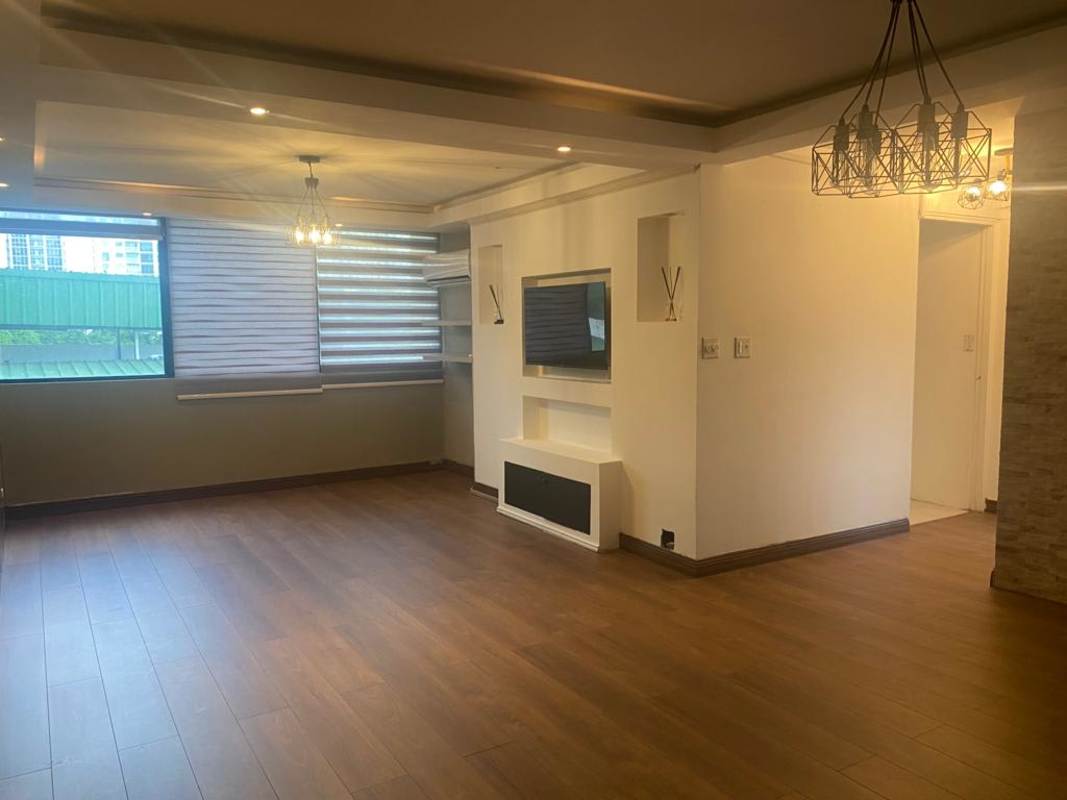 Living room with ceiling lights, TV wall unit, large window and wood-look flooring in PH Mirador San Francisco Panama