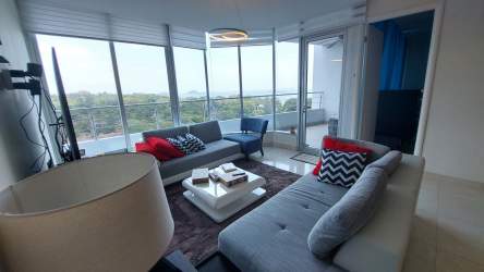 Bright modern living room overlooking balcony with ocean view at Casa Bonita Veracruz Panama