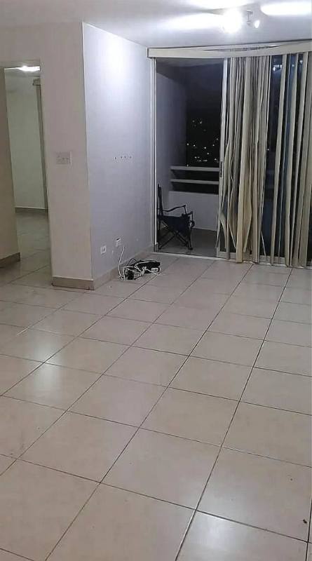 Empty tiled living room and sliding door leading to balcony nighttime city view PH Carrasquilla Park Panama City