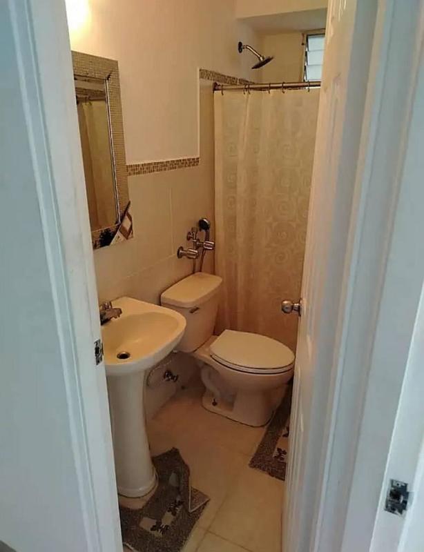 Small bathroom with pedestal sink, tiled walls and shower at PH Carrasquilla Park Panama City