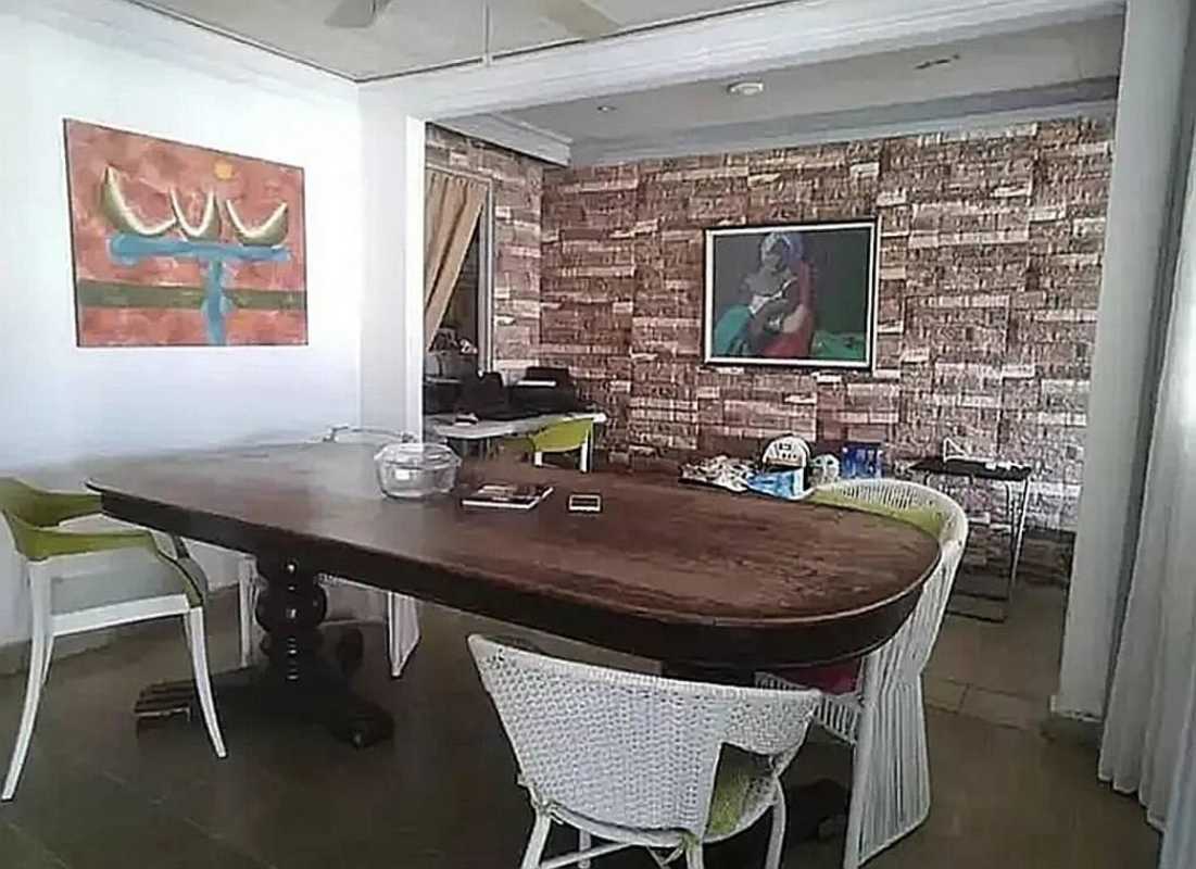 Dining room with wooden table, wicker chairs, and brick wall accent Santa Clara Panama