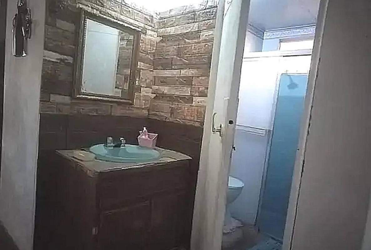 Rustic bathroom with wooden walls, blue sink and shower stall in Santa Clara Panama