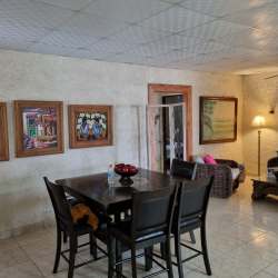 Spacious country style kitchen with island, white cabinets and tiled counters in Chame estate Panama