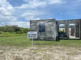 Concrete block home under construction on large corner lot with for sale sign in Hacienda Pacifica Panama
