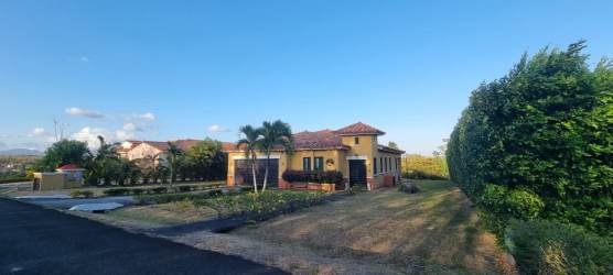 Front view with tile roof, driveway, garage, and lush garden in Hacienda Pacifica San Carlos Panama