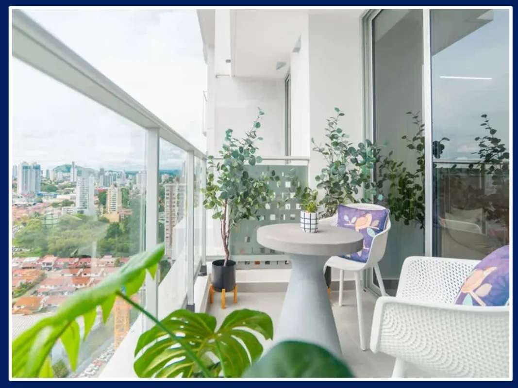 Modern balcony with glass railing, plants, city view PH RISE Via España Panama City