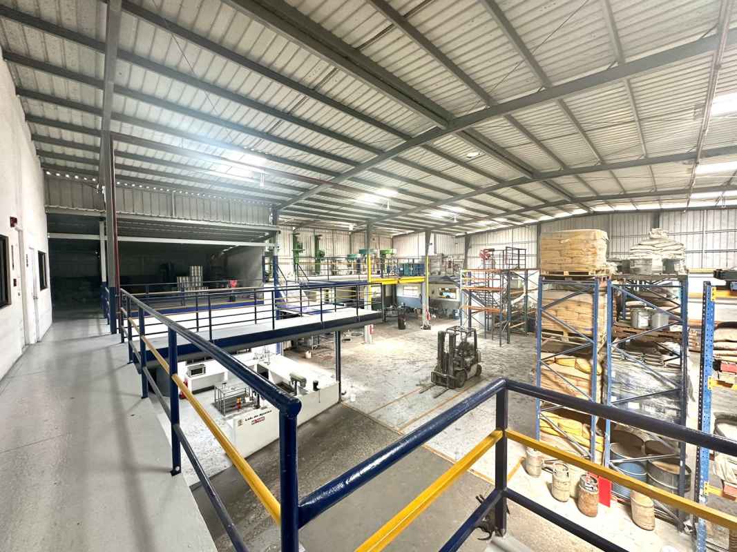 Industrial warehouse interior with high ceiling, storage racks and forklift in Panama City