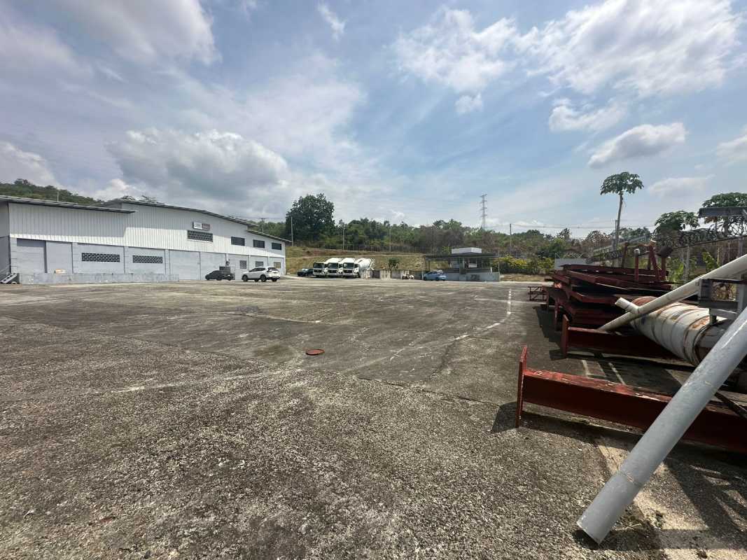 Expansive concrete yard with trucks and industrial warehouse in Panama City