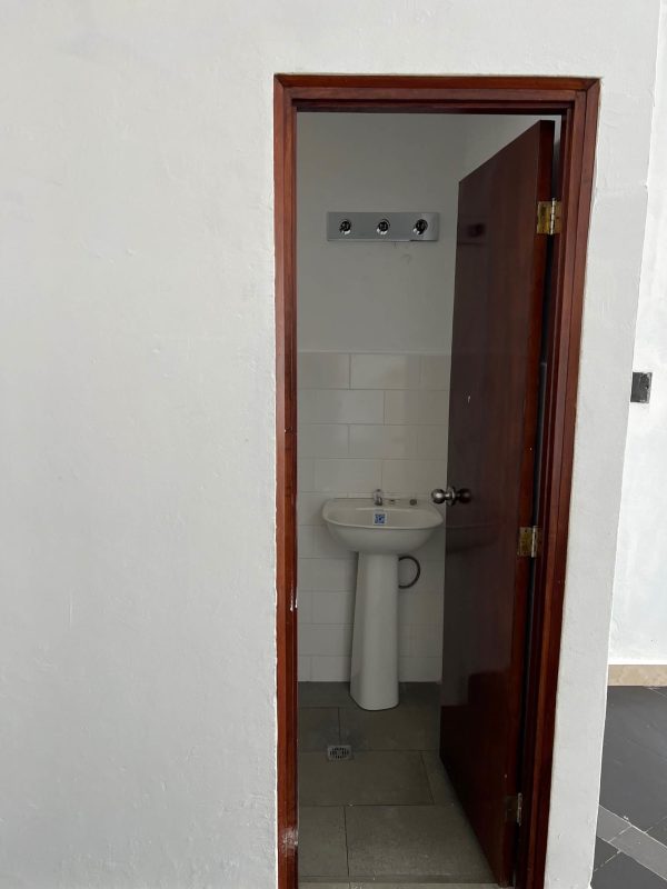 Modern bathroom inside commercial space with white tiles and sink in Obarrio