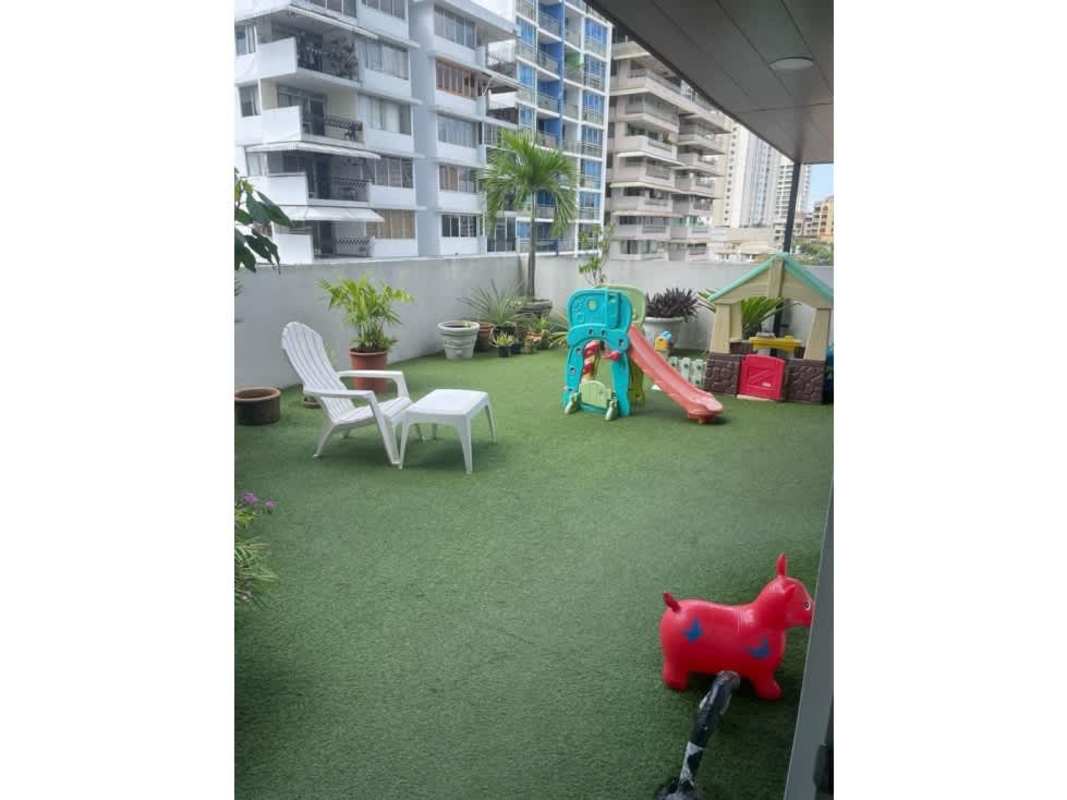 Bright living dining space with wood floors, green accent wall at Cangrejo 507 apartment Panama