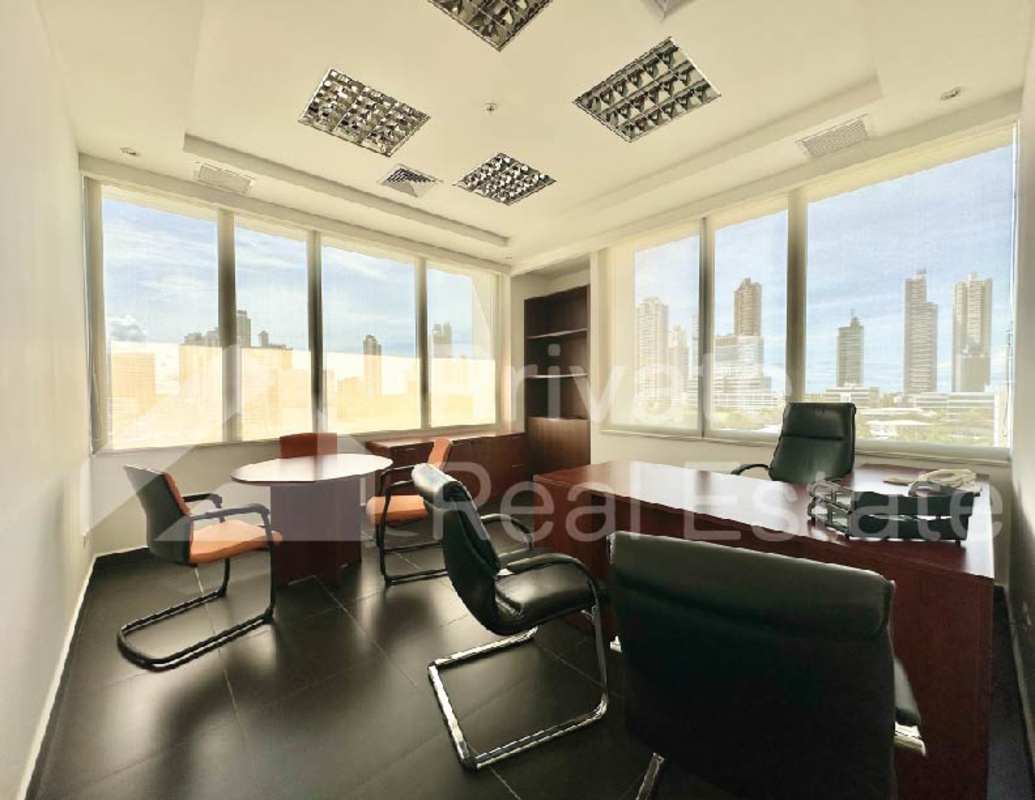 Modern office with glass partitions and skyline views in Torre Centenario