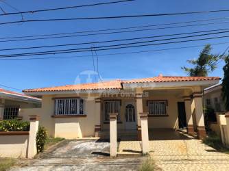 Traditional living room with black leather sofas, fan, decorative touches in Chitré Panama