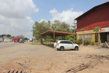 Warehouse building roadside with carport dirt lot trees Panamericana Aguadulce Panama