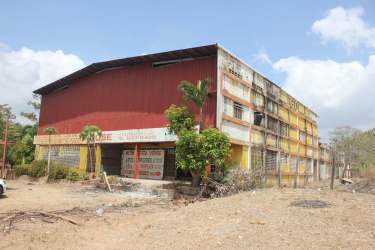Three-story commercial building along Pan-American Highway in Aguadulce with red roof commercial signage