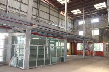 Large empty interior warehouse space with high ceiling beams and concrete floor Aguadulce