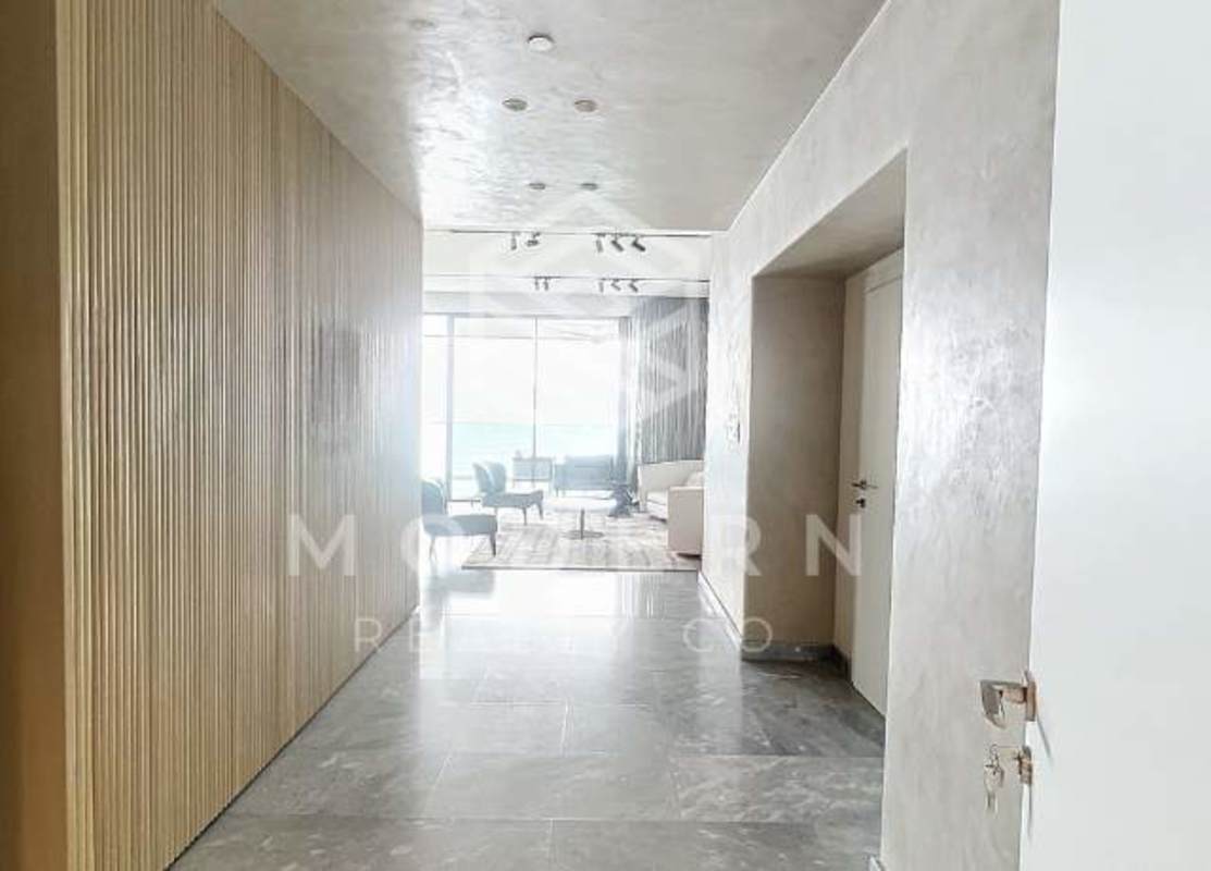 Open dining space with modern kitchen and large island in PH Costa del Mar Costa del Este