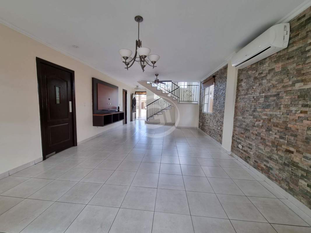 Living room with large windows, porcelain floors, AC, ceiling fan and stone accent wall in house for sale Panama