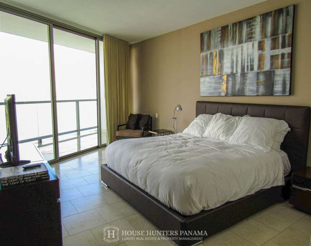 Master bedroom with king bed, balcony access, floor-to-ceiling windows, panoramic ocean views at The Ocean Club Punta Pacifica Panama