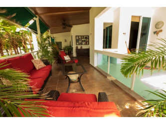 Modern living room with stone accent wall, large sofa, TV, and ceiling fan in Playa Blanca Panama