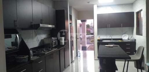 Kitchen with dark wood cabinets, island, and appliances in Chitré Panama