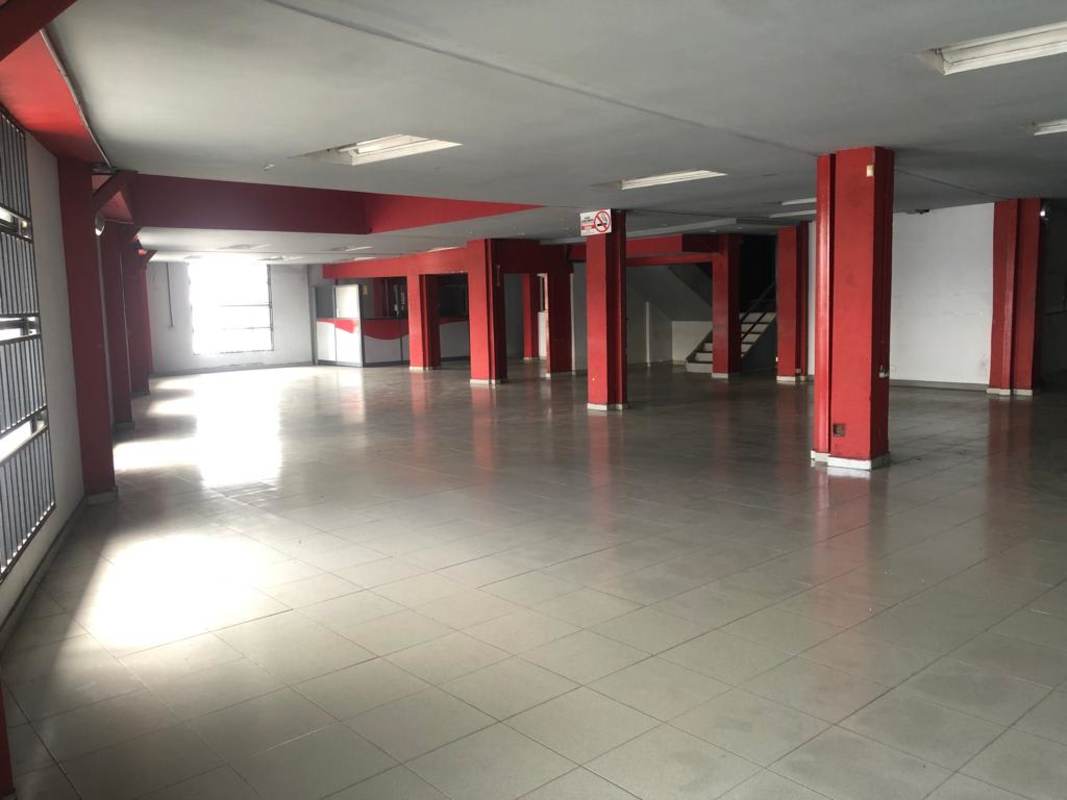 Large unfurnished commercial space with tiled floors and support beams in Casa Gala Calidonia