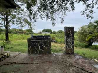 Stone steps through large grassy yard with trees leading to water in Lago Mar San Carlos