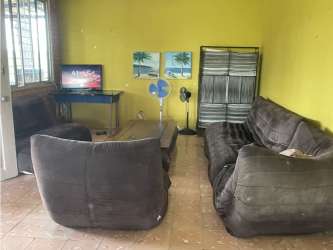 One story peach house metal gate barred windows garden yard Lago Mar Panama