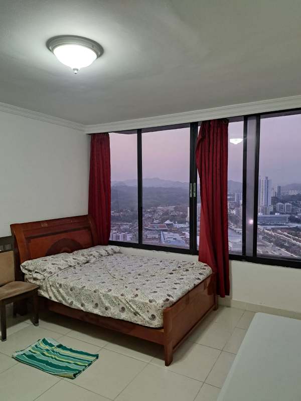 Bedroom with large windows, panoramic city view, wood bed, tile floors in Pacific Hills Panama City