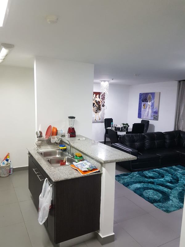 Modern apartment kitchen with granite countertops, stove, and cabinets in PH Colores de Bella Vista Panama City