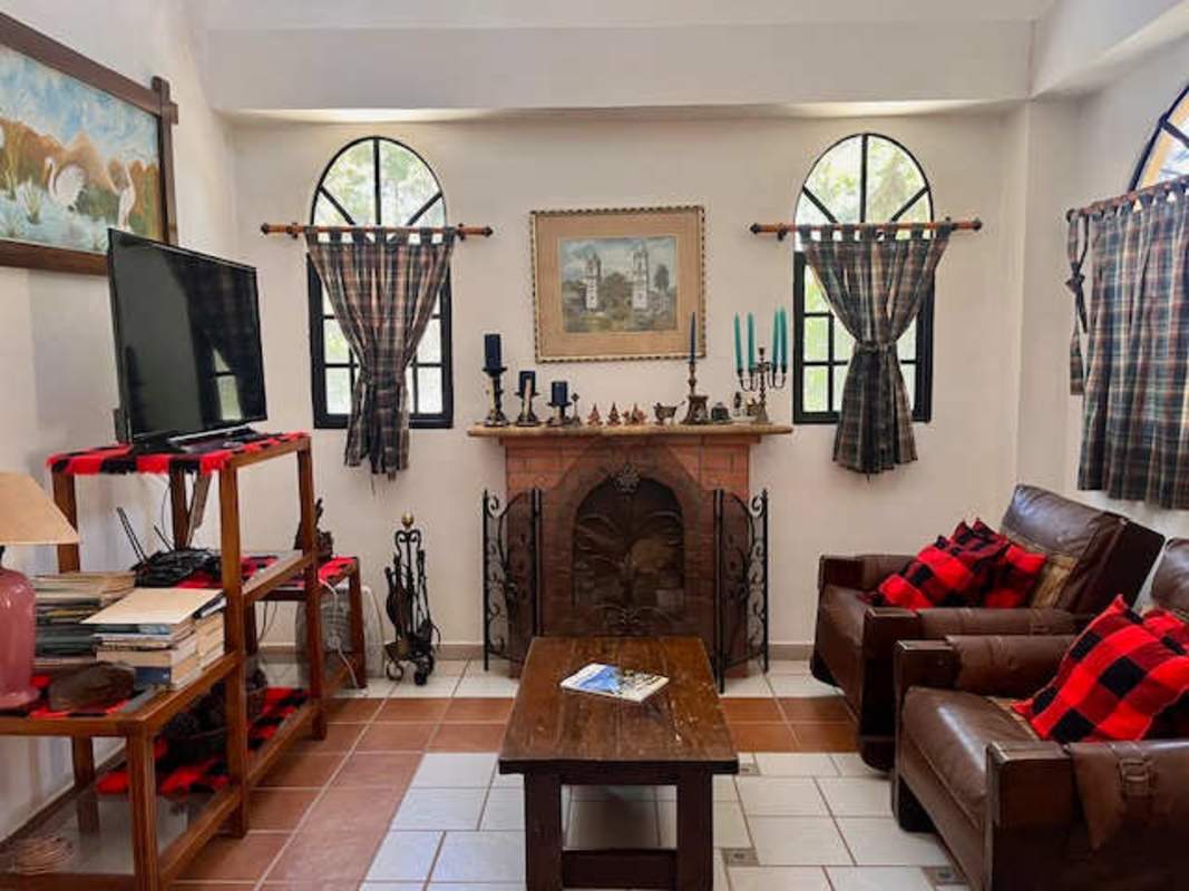 Spacious rustic kitchen with granite counters, wood cabinetry, checkered tile floor, large arched window in Panama